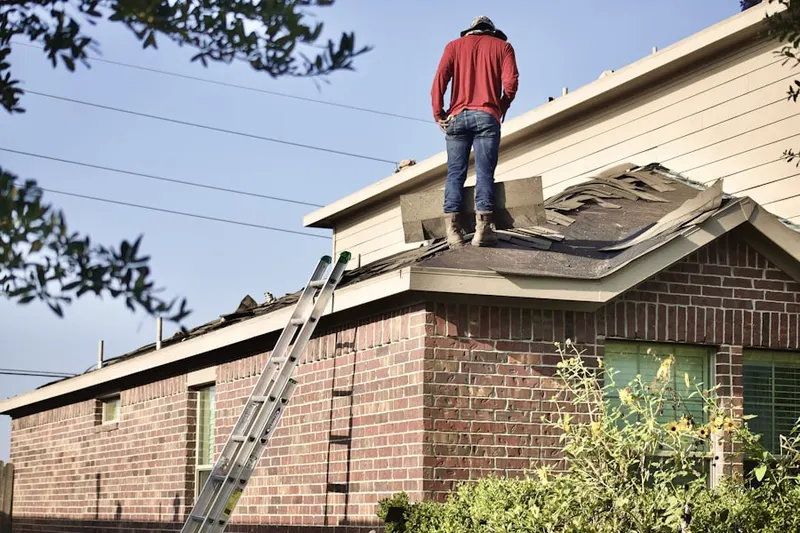 Professional roofer working on a residential roof in Laurel Hollow